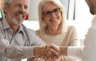 Couple shaking hands with a title agent
